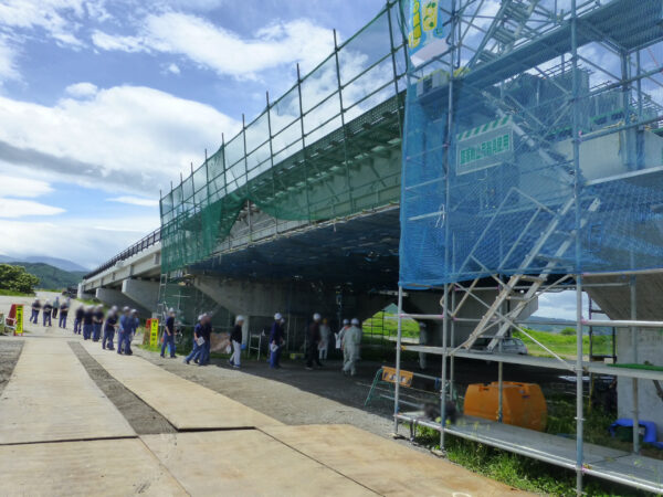 高校生の現場見学会。浅蓼大橋に高校生たちが到着して移動している様子の画像。