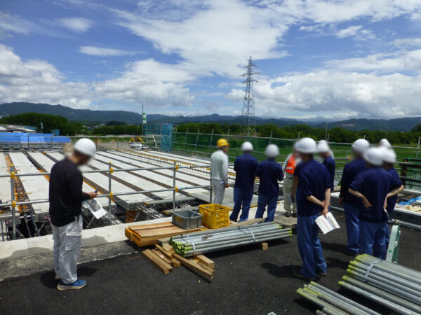 高校生の現場見学会。別角度から撮影した現場見学中の生徒と工事の様子の画像