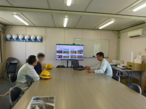 2日目の長野県佐久市中込に建設中の野沢児童館の現場見学。事務所内で工事内容の説明を受けている様子の画像。