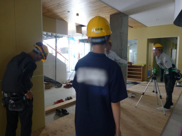 2日目中学生の職業体験。先輩社員と会話をしつつ、墨だし作業を見学をしている様子。