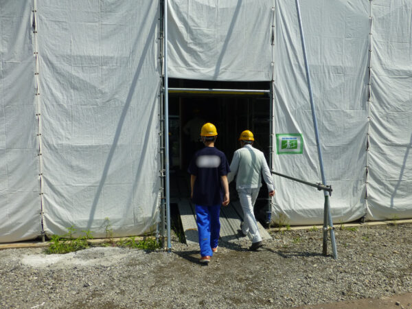 建築の現場見学。建設中の建物内へ入ろうとしている様子の画像。