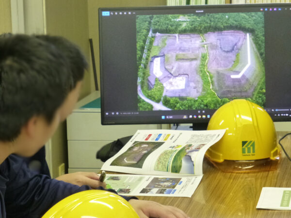 竹花組職業体験で、工事現場事務所で工事内容の説明を聞いている様子