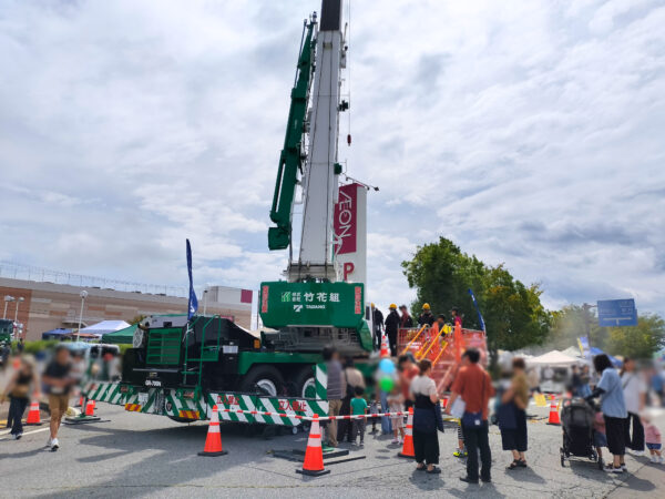 第3回まるごとつながるフェスタ佐久平イベントにて竹花組ブースのクレーン乗車体験の様子の画像。