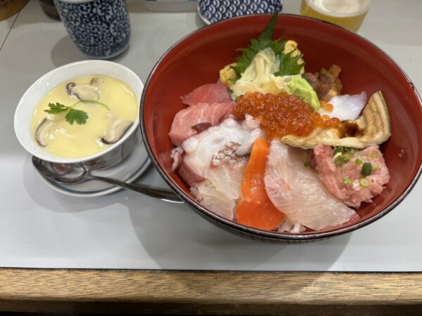 築地のお店にて、いろんなお刺身が乗ったどんぶりと茶碗蒸しなどの画像。