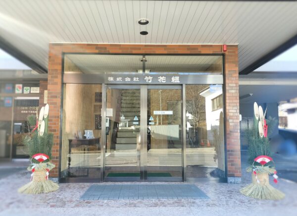 ２０２６年新年のあいさつ。この画像は、竹花組本社の入口。入口の両端に大きな門松を飾っている。