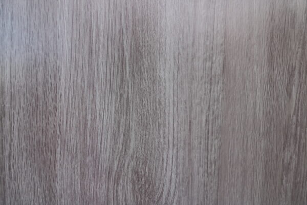 共同住宅の玄関ドアの模様をアップで撮影した画像。グレージュの木目調のドア。