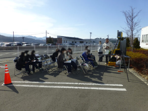 東御清翔高等学校の地域交流イベント東御清翔メッセで竹花組ブースで測量機器と建設業とはの説明をしている画像