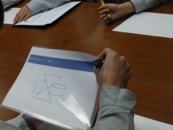 伝達ゲームで話す人が一生懸命図形を伝えているシーン